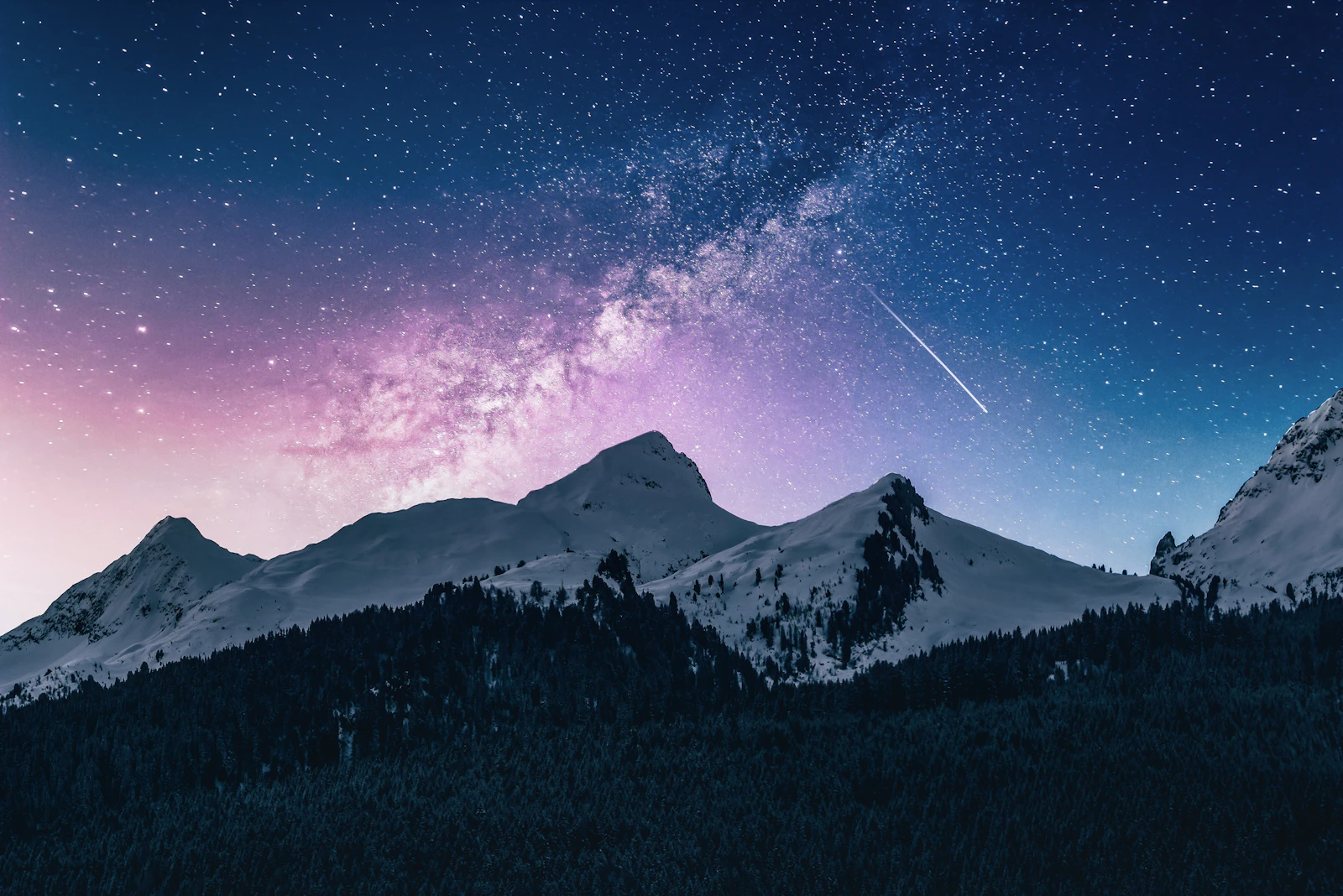 The Milky Way and a meteor streak over snow-covered alpine peaks